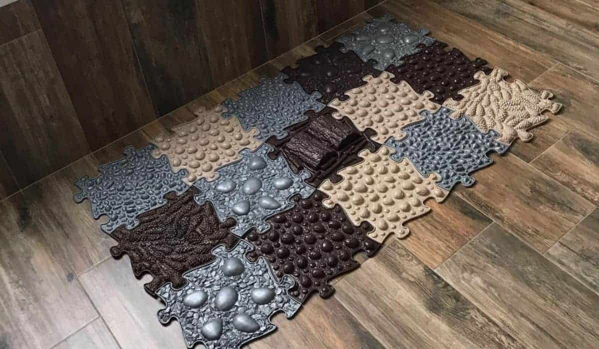 Mats on the floor in front of a bath in brown colourn grey